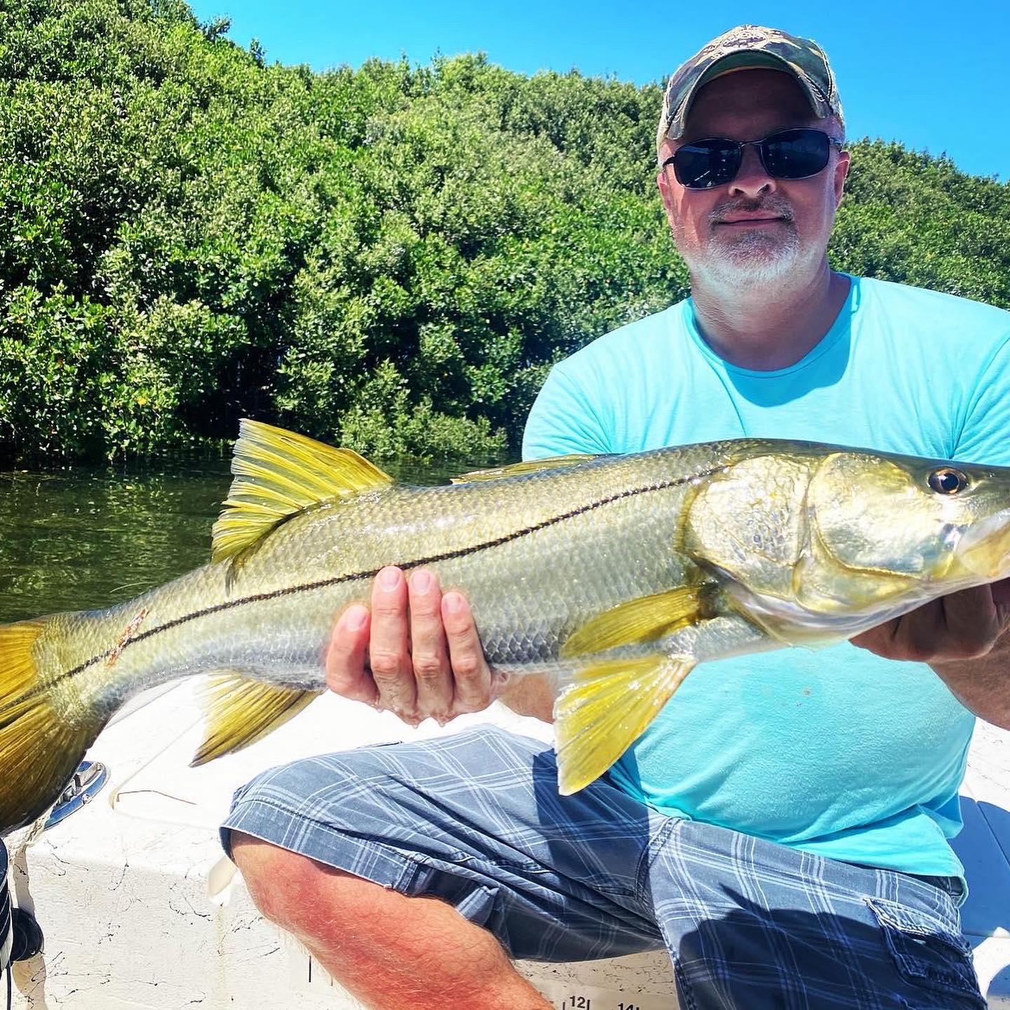 a fisherman on a crystal river fishing trip holding a snook they caught