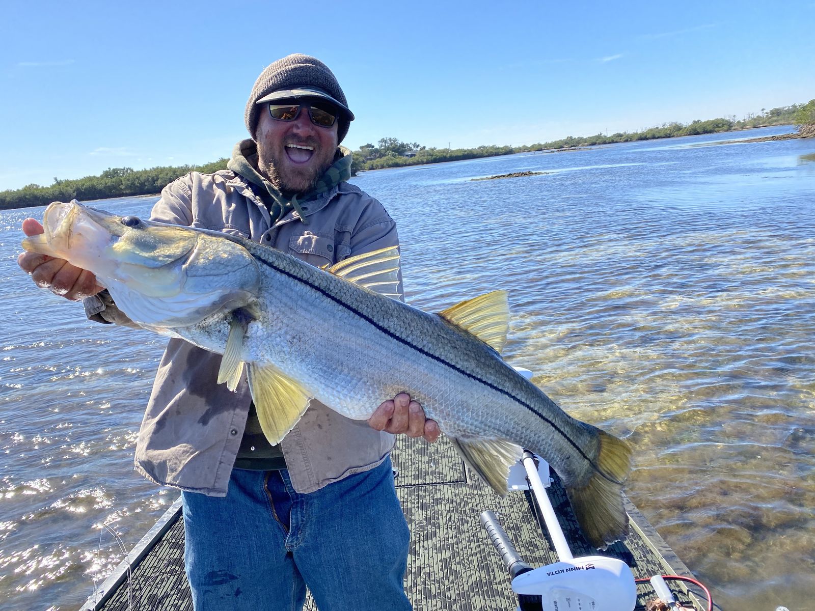 a picture of a fisherman holding a snook caught on a very shallow flat in Crystal River