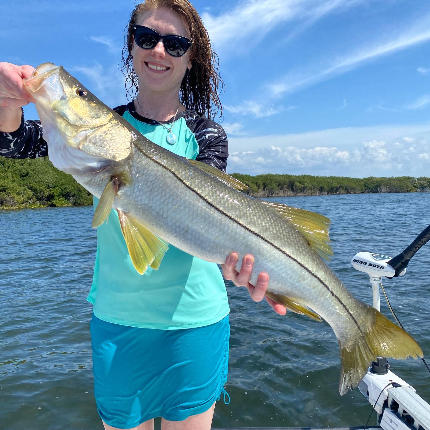 a fisherman on a crystal river fishing charter holding a snook they caught