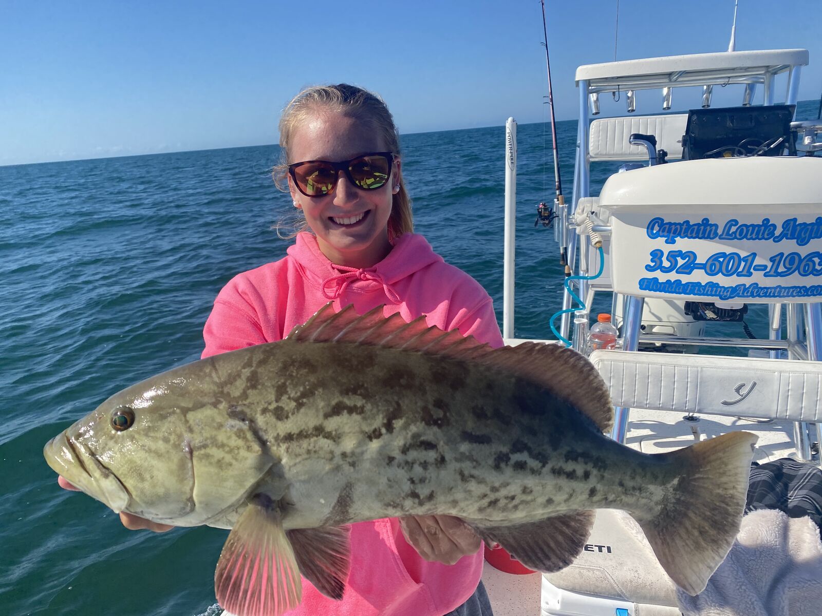 a fisherman holding a grouper they caught on a crystal river fishing charter