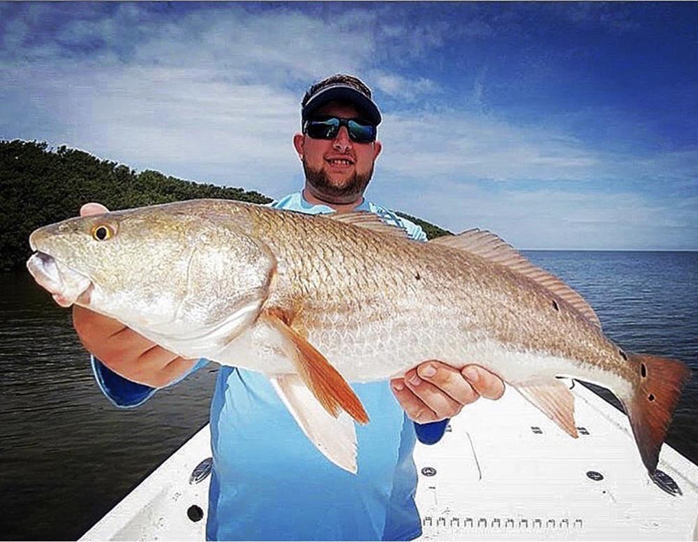 a picture of Captain Loui holding a resfish he caught in Crystal River