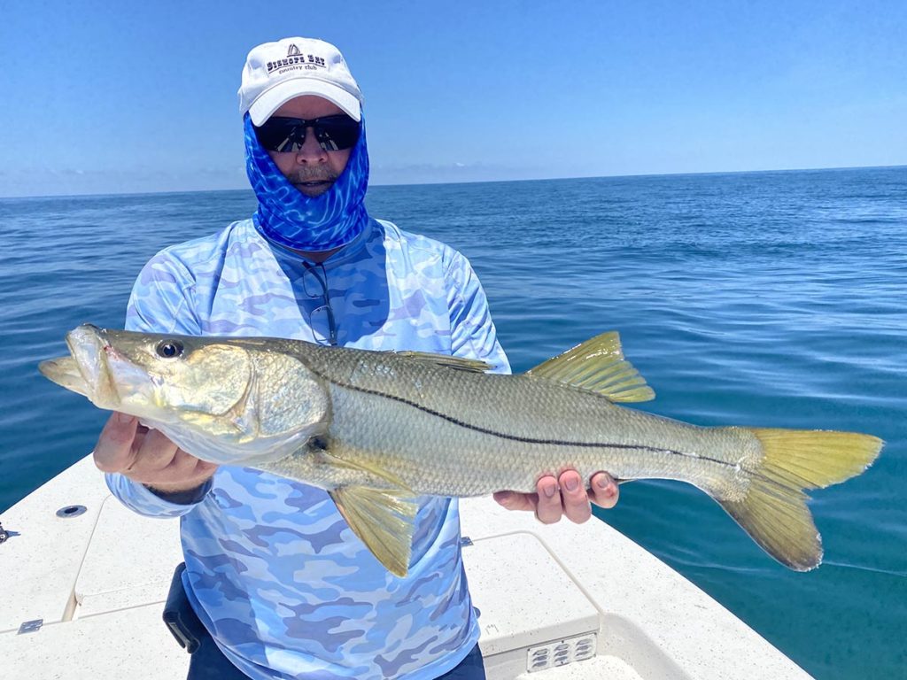 a picture of a fisherman with a snook he caught on a crystal river fishing charter