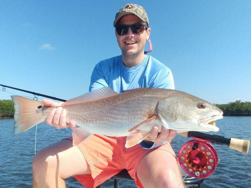 a fly fisherman with a redfish