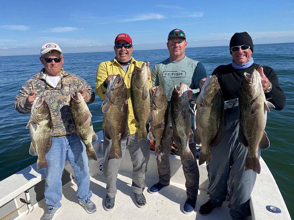 A group of fisherman holding grouper on a crystal river fishing charter