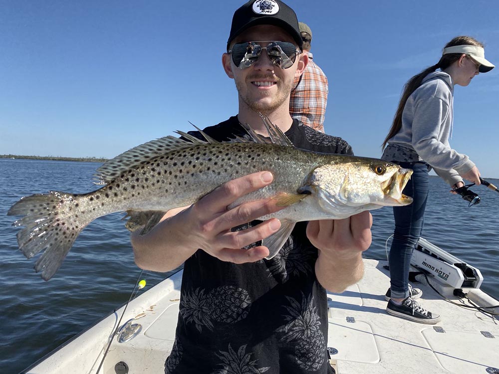 a picture of a fisherman holding a sea trout that was caught while sight fishing in Crystal River