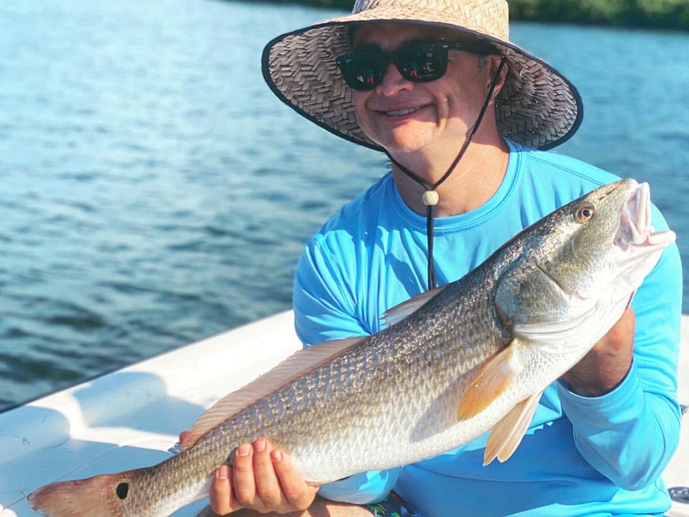 a fisherman with a redfish