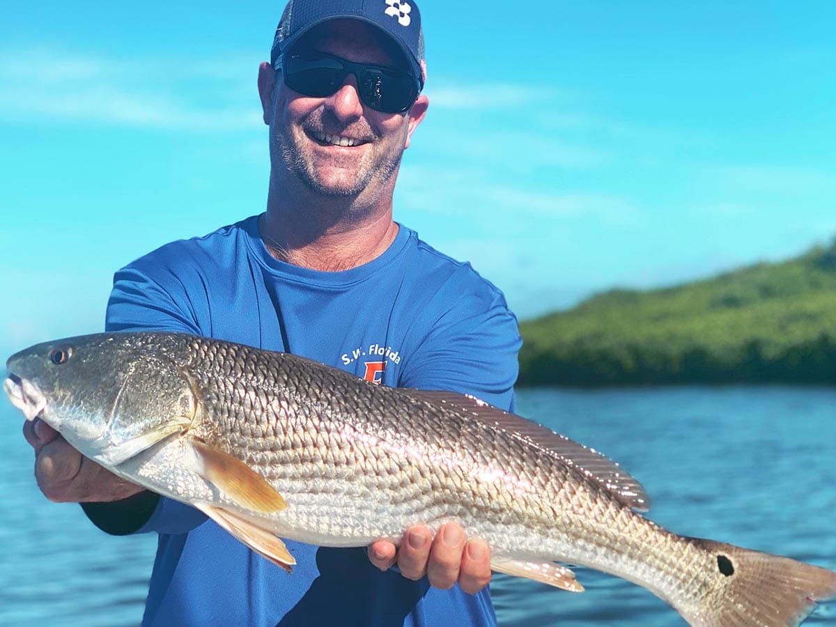 a fisherman with a redfish