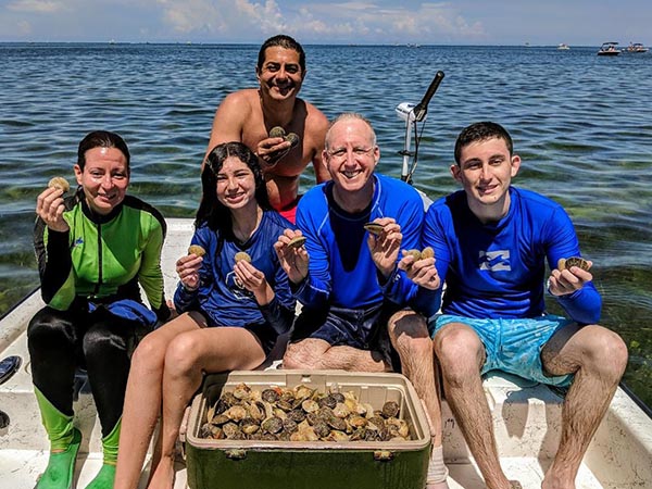 a picture of a family holding scallops they caught